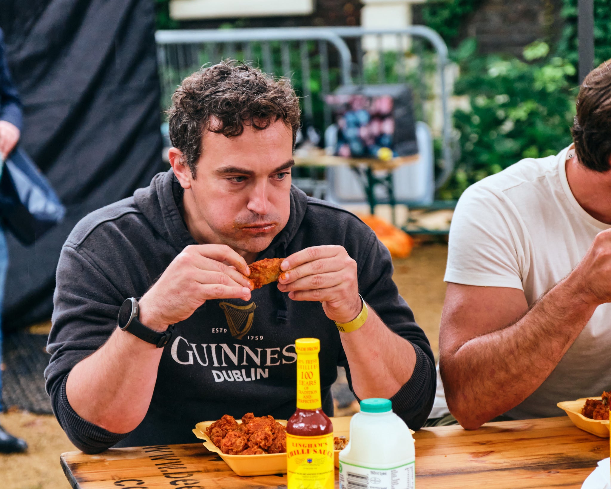 a guy eating hot wing at the hot wing contest at wingjam, wingJam London A Celebration of Great Wings and Good Friends, WingJam London The Best Place to Enjoy Chicken Wings with Friends, WingJam London A Festival for Friends Who Love Good Food, WingJam London Friends Savoring Every Wing, WingJam London A Flavorful Gathering of Chicken Wing Fans