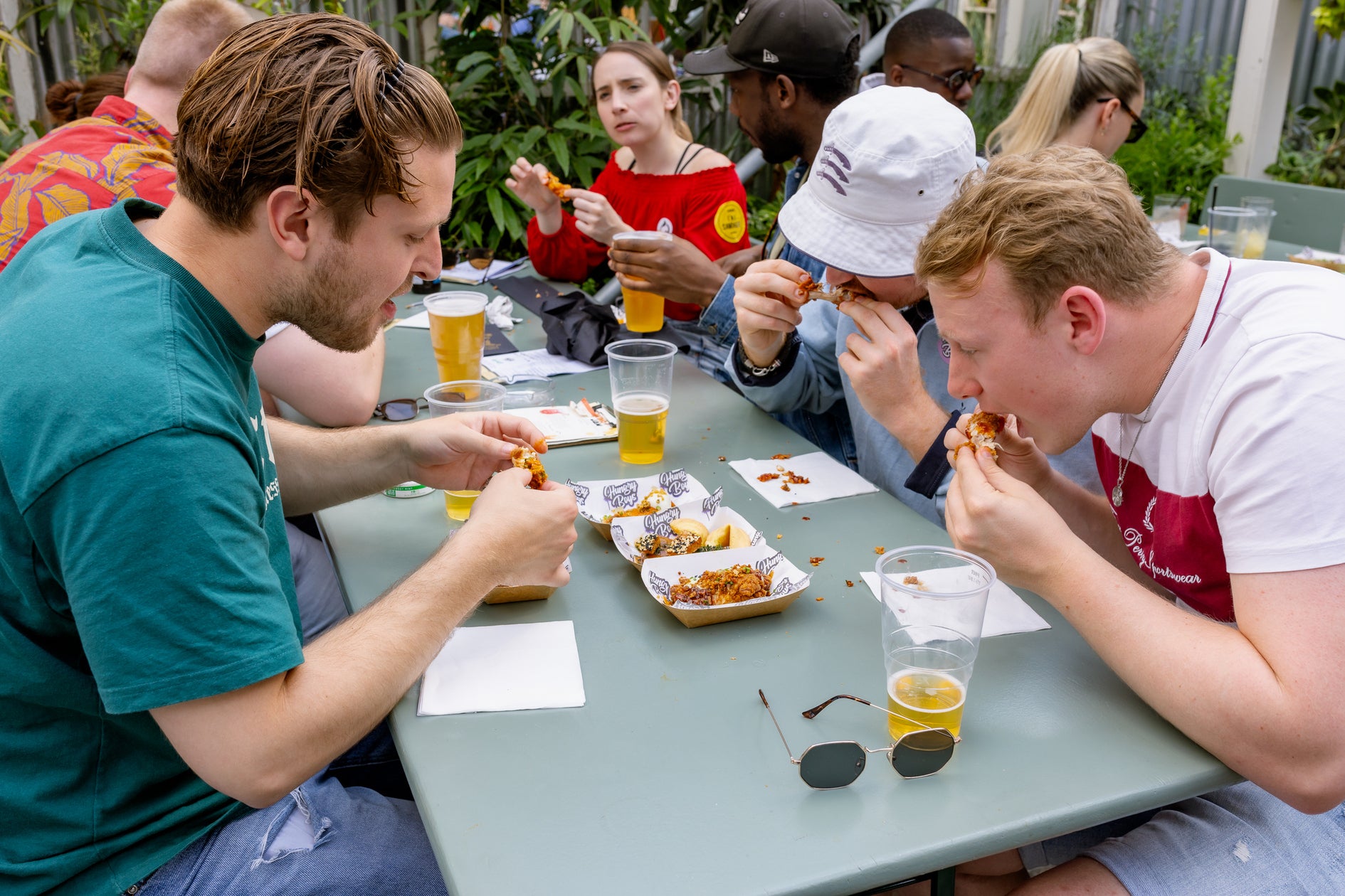 visitors enjoying chicken wings from hungry boys at wingjam, WingJam London Where Friends Feast on Tasty Wings, WingJam London A Fun Day Out with Friends and Wings, WingJam London Where Foodies Savor the Best Wings, WingJam London People Loving the Flavor-Packed Chicken Wings